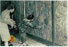 Nyonya Tien Suharto memperagakan lukisan relief pada bangunan Joglo.
