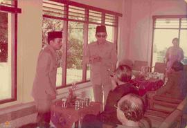 Sri Sultan Hamengku Buwono IX (duduk membelakangi kamera sambil mengangkat tangan kanan) berbinca...