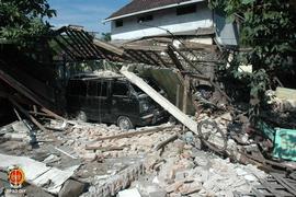 Sebuah mobil di daerah selatan Jembatan Winongo tertimpa reruntuhan bangunan akibat gempa bumi be...
