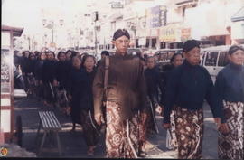 Di belakang bapak-bapak tampak rombongan ibu-ibu dengan pakaian adat Jawa tidak mau ketinggalan m...