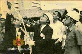 Sri Sultan Hamengku Buwono IX menyaksikan Drs. Radius Prawiro menarik tali pada tiang pancang ged...
