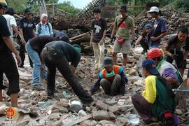 Beberapa relawan sedang mencari korban gempa di Dusun Bawuran, Pleret, Bantul yang masih tertimbu...