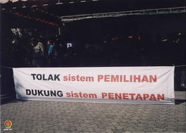 Masyarakat berpakaian Jawa saat demo dengan spanduk bertuliskan “tolak sistem pemilihan, dukung s...