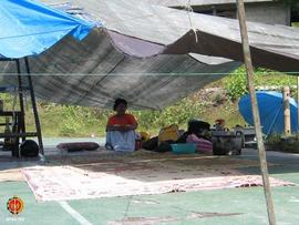 Ibu Danu Wresni sedang duduk di bawah tenda pengungsian masal di sebuah lapangan badminton di Des...