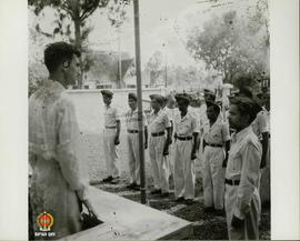 Seorang tentara asing berdiri di depan barisan TNI sedang menerima laporan dari seorang Komandan ...