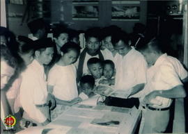Para pengunjung Pekan Raya Nasional Dwi Dasa Warsa sedang memperhatikan gambar Presiden Soekarno ...