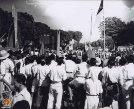Para peserta Peringatan Hari Satu Mei berjubel mengelilingi tempat upacara sambil membawa Bendera...