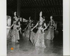 Empat penari sedang menari dengan lemah gemulai di sebuah pendapa diiringi penabuh gamelan.