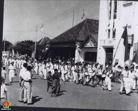 Rombongan drum band peserta upacara meninggalkan Alun-Alun melewati depan Bank Negara Indonesia.