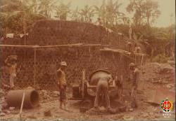 Beberapa pekerja sedang menggunakan alat molen dalam proses pembuatan dinding bendungan
