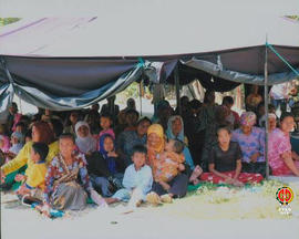 Warga duduk dibawah tenda darurat pada saat acara penyerahan bantuan kepada korban gempa kerja sa...