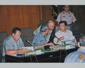 Jusuf Kalla sedang berdiskusi dengan Menteri Sosial Bapak Bachtiar Chamsyah, dan anggota rapat la...