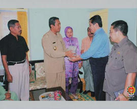Wakil Bupati Labuhan Batu Sumatera Utara (berbaju keki) menyerahkan bantuan uang tunai sejumlah 1...