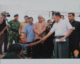Wakil Presiden RI Yusuf Kalla sedang berjabat tangan dengan seorang korban bencana gempa bumi di ...