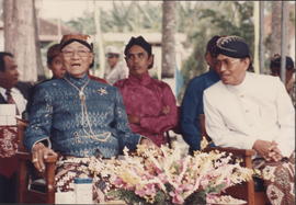 Sri Paku Alam VIII sedang duduk di tribun upacara didampingi oleh Bupati Kulonprogo.