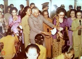Presiden Soeharto dan Ibu Tien Soeharto sedang mengamati topeng hasil karya Ibu-ibu PKK