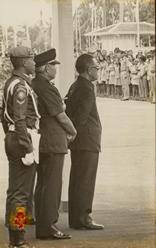 Wakil Presiden Republik Indonesia bersama seorang pejabat dan seorang pengawal berdiri saat menda...