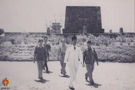 Panglima Besar Jenderal Soedirman sedang berjalan di halaman Taman Makam Pahlawan dan Drs. Moh. H...