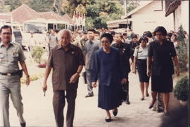 Presiden Soeharto dan Ibu Tien Suharto didampingi Menkes RI Achmad Suyudi menuju lokasi barak pen...