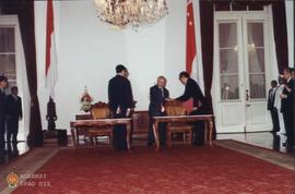 Menteri Perindustrian RI Ir Hartarto berjabat tangan dengan Presiden Soeharto setelah penandatang...
