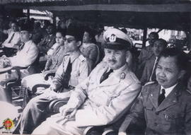 Panglima Besar Jenderal Soedirman berkacamata dan berdasi hitam sedang duduk bersama menghadiri p...