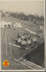 Beberapa anggota Pramuka sedang istriahat duduk di tikar luar tenda.