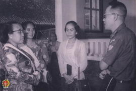 Bapak Marsudi sedang menyambut Ibu Soedirman beserta rombongan tamu lainnya di halaman rumah Bapa...